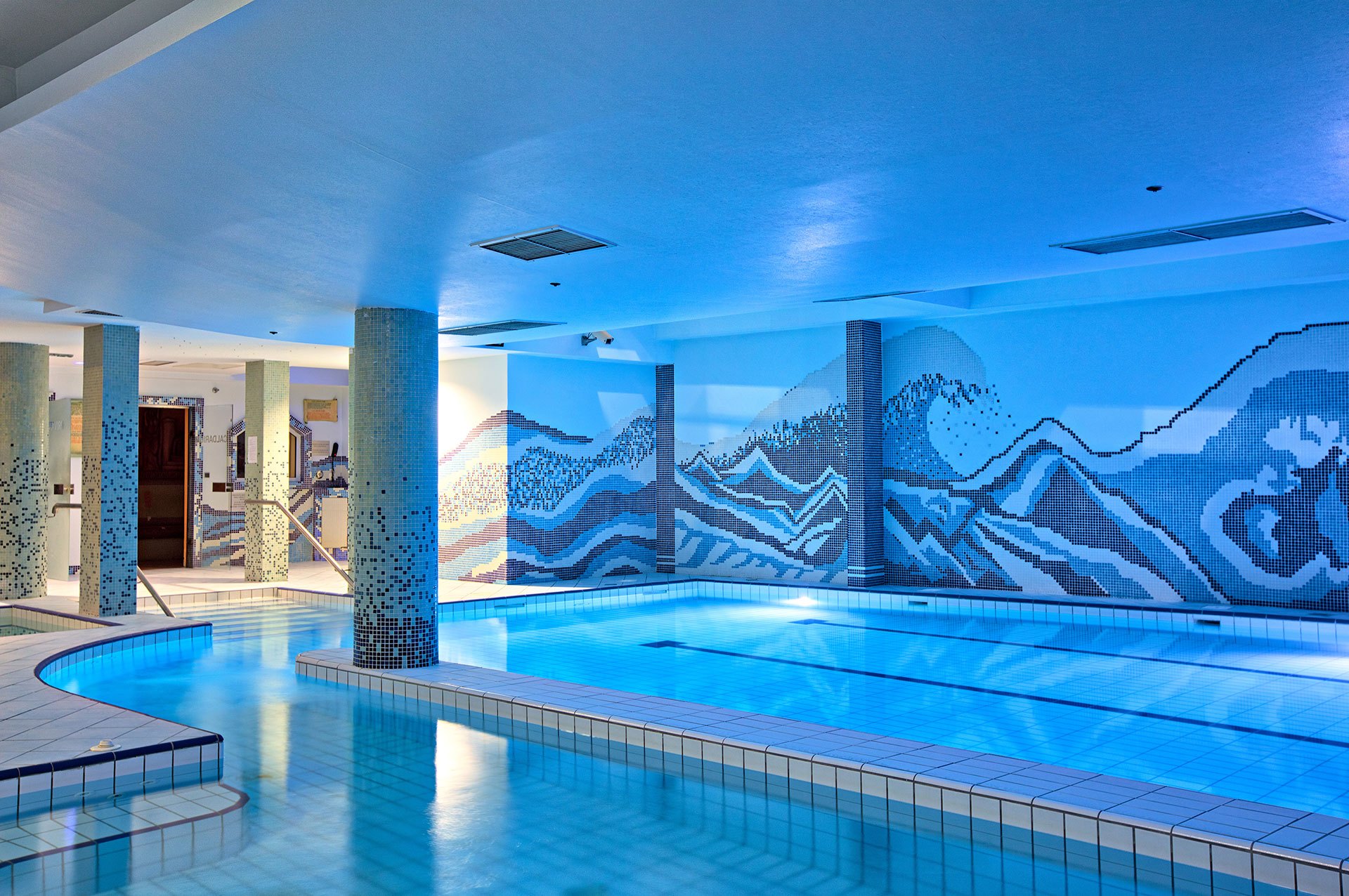 The indoor pool and mosaic wall of Hotel Central’s spa